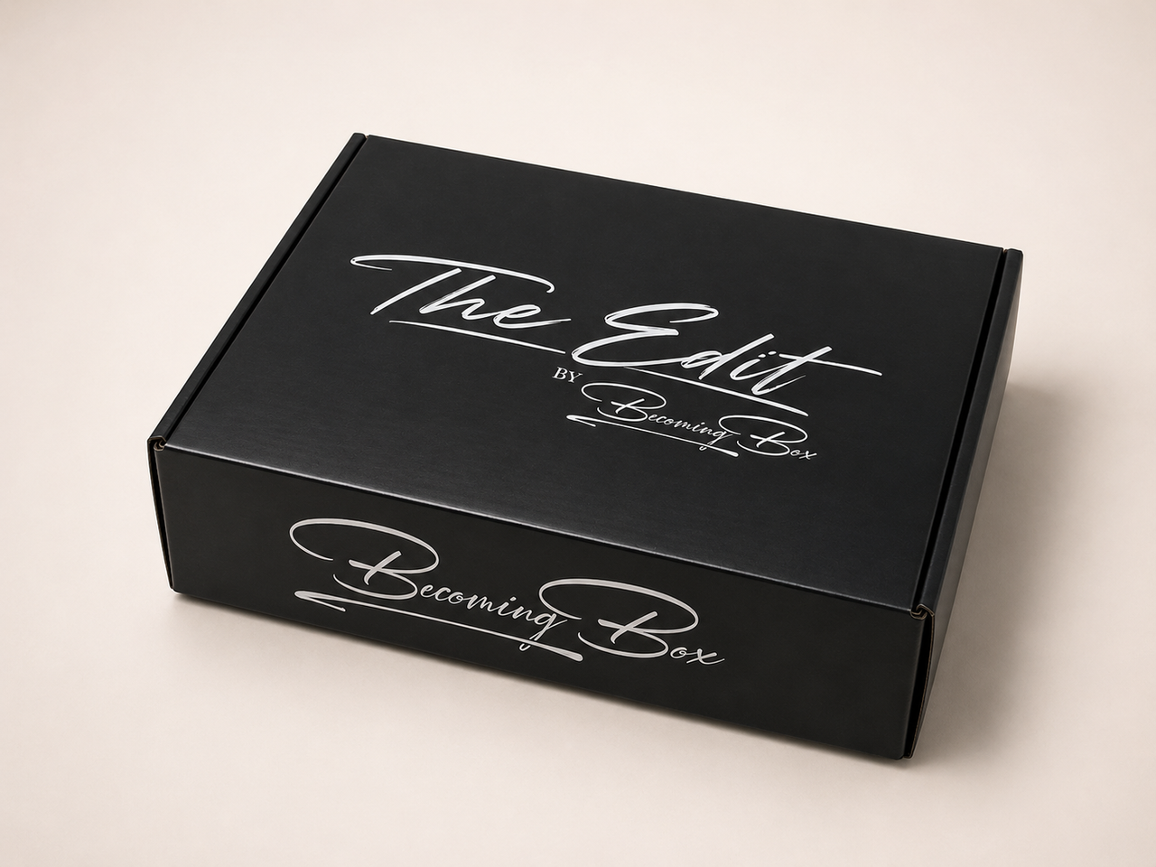 The Edit by Becoming Box — a black subscription box with silver script logo