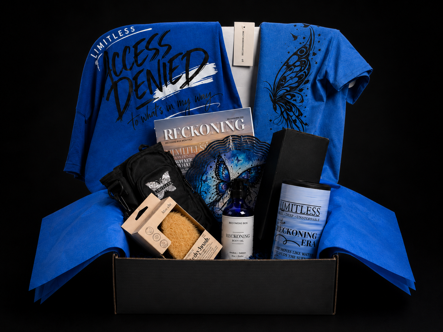 Reckoning subscription box with Access Denied tee, Limitless butterfly tee, Reckoning magazine, body oil, sponge, and water bottle